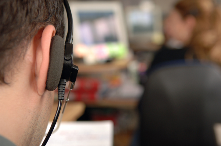 Extreme close-up of man wearing headset at contact centre